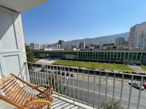 a balcony with a bench and a view of a city at Luxury Apartment in Tbilisi City Centre in Tbilisi City