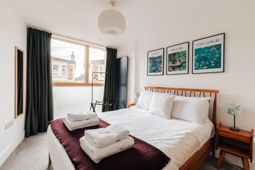 een slaapkamer met een bed met twee handdoeken erop bij Redland Stay In Bespoke Home 2 of 2 in Bristol