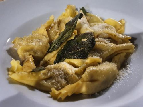 a plate of food with pasta on a white plate at il Glicine B&B RISTORANTE in Cazzago San Martino
