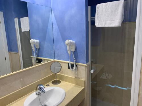 a bathroom with a sink and a mirror and a shower at Marina de Campios in Comillas