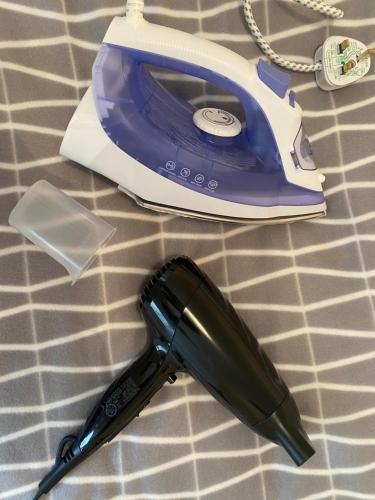a hair dryer and a phone on a bed at Elmcroft Apartments Halifax City Centre in Halifax
