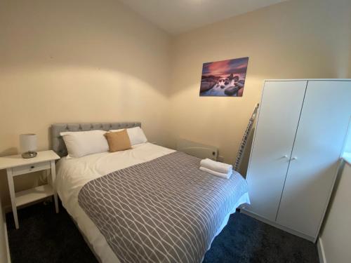 a small bedroom with a bed and a night stand at Elmcroft Apartments Halifax City Centre in Halifax