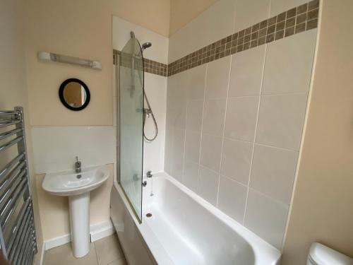 a bathroom with a tub and a sink and a shower at Elmcroft Apartments Halifax City Centre in Halifax