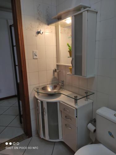 ein Badezimmer mit einem Waschbecken, einem Spiegel und einem WC in der Unterkunft Apartamento em Balneário Camboriú centro,quadra mar in Balneário Camboriú