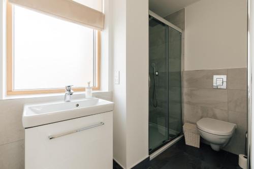 a bathroom with a sink and a toilet and a window at Redland Stay In Bespoke Home 1 of 2 in Bristol