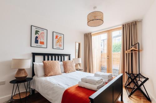 1 dormitorio con 1 cama con sábanas blancas y ventana en Redland Stay In Bespoke Home 1 of 2 en Bristol