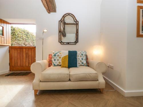 a living room with a couch and a mirror at The Forge in Taunton