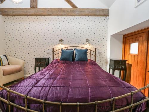 a bedroom with a large bed with a purple comforter at The Forge in Taunton
