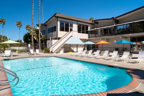 a swimming pool with chairs and a building at San Clemente Inn in San Clemente