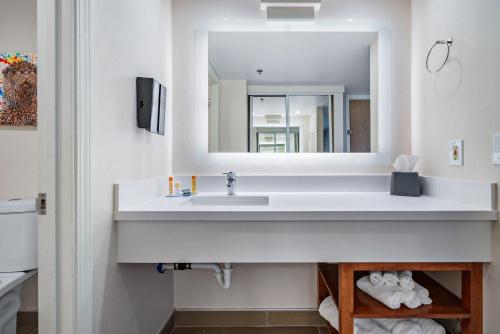 a bathroom with a sink and a mirror at Hotel Avisa Downtown in Morro Bay