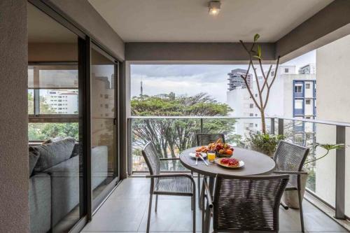 聖保羅的住宿－Noon Vila Madalena，客房设有桌椅和大窗户。