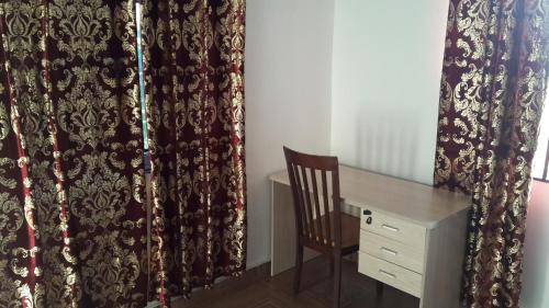 a room with a desk and a chair and curtains at Hayben serviced apartments in Accra