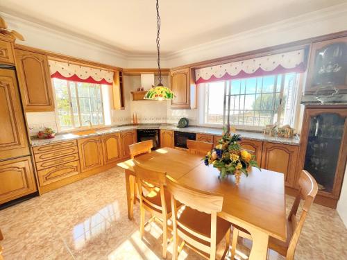 duża kuchnia z drewnianym stołem i krzesłami w obiekcie Villa for nature lovers w mieście Vilaflor
