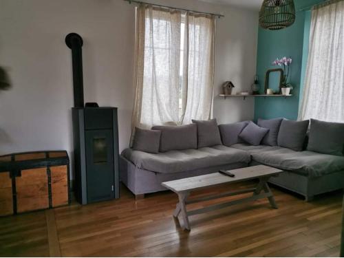 ein Wohnzimmer mit einem Sofa und einem Couchtisch in der Unterkunft Gite mes pt'tis lits maison chaleureuse 4 chambres 