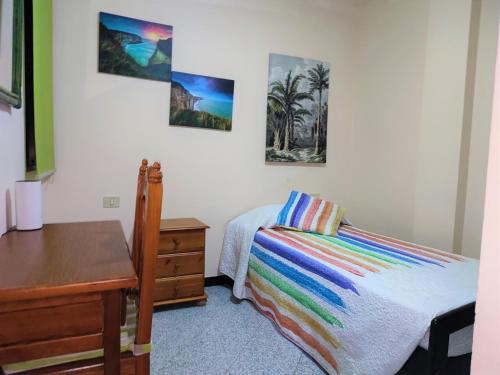 - une chambre avec un lit, un bureau et des photos sur le mur dans l'établissement Apartment Severo Ochoa, à Puerto del Rosario