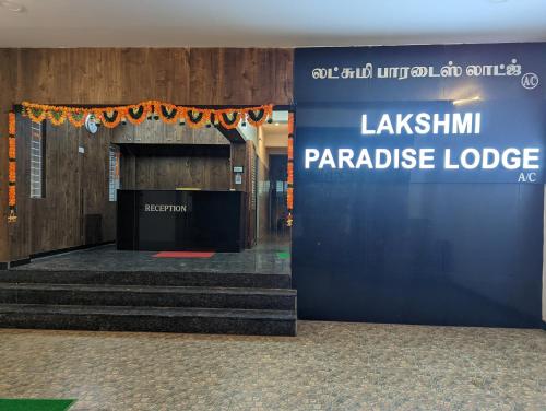 a lobby with a blue wall and stairs in a building at Lakshmi Paradise Lodge A/C in Pollāchi