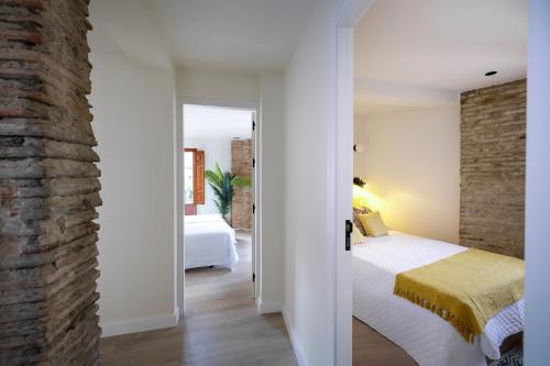 a bedroom with a bed and a brick wall at Albaicin Alhambra Views private terrace in Granada