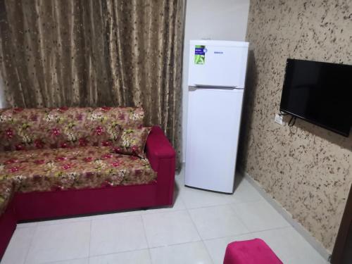 a living room with a couch and a refrigerator at Al-Shokhaibie 51 Building- Soufan Studios in Ţāb Kirā‘