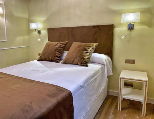- une chambre dotée d'un lit avec des draps blancs et 2 oreillers dans l'établissement SUITES SAN ESTEBAN 16 Ducal, à Séville