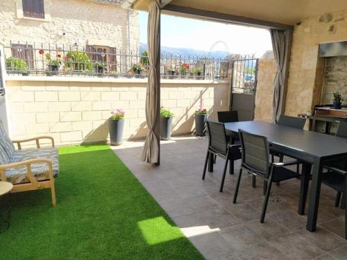 un patio con mesa, sillas y césped verde en Casa "El Villar", en Matabuena
