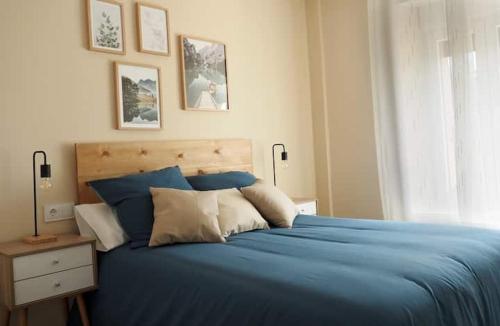 Un dormitorio con una cama azul y una ventana en Casa "El Villar", en Matabuena