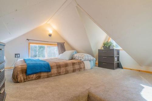 Schlafzimmer im Dachgeschoss mit einem Bett und einem Fenster in der Unterkunft The Skarland Trail Cabin in Fairbanks