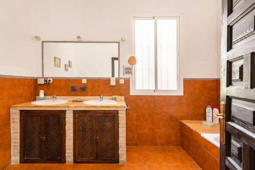 baño con 2 lavabos y espejo grande en Casa Rural Navalonguilla con piscina en Santa Olalla del Cala