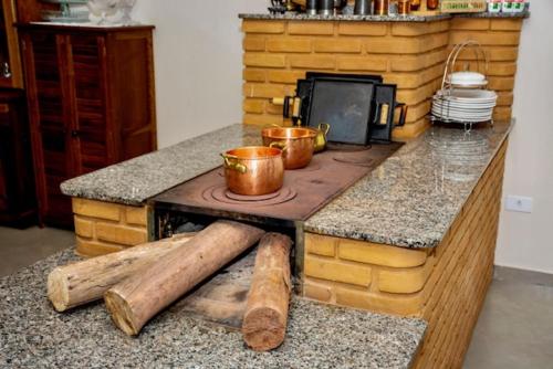a kitchen with a counter with two pots and pans at Pousada Pôr do Sol in Cunha