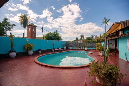 a swimming pool in the middle of a courtyard at Hosteria Los Helechos in Puerto Iguazú