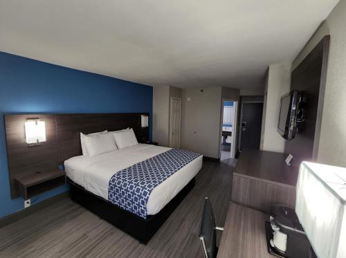 1 dormitorio con 1 cama grande y pared azul en La Quinta by Wyndham Houston Stafford Sugarland en Stafford