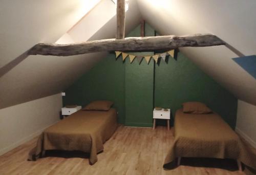 a attic room with two beds and a tree branch on the ceiling at Advitamrelais in La Rouquette