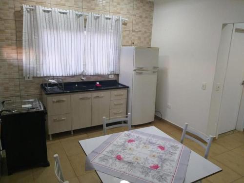a kitchen with a refrigerator and a table in it at HAPPY HOSPEDAGENS in Cascavel