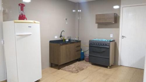 a kitchen with a refrigerator and a stove at HAPPY HOSPEDAGENS in Cascavel