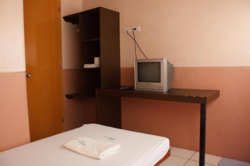 a room with a desk with a tv on a table at GV Hotel - Sogod in Sogod