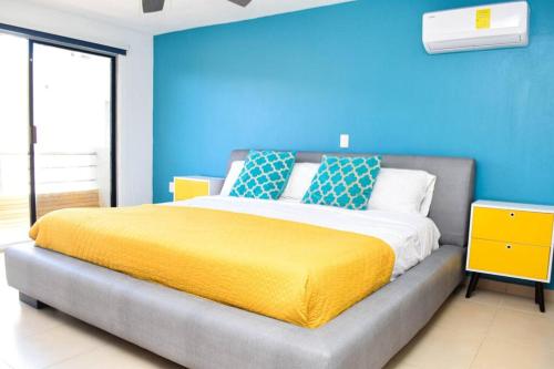 a bedroom with a bed with a blue wall at Ocean view apartment, best beach area, 3 bedrooms in Cancún