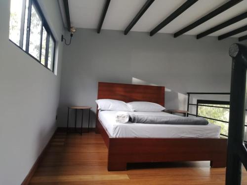Schlafzimmer mit einem Bett mit einem Kopfteil aus Holz in der Unterkunft Finca 2 - Dakeva in Guatapé