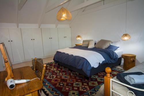 a bedroom with a bed and a table and a table sidx sidx at DE VISSCHUUR in Paternoster
