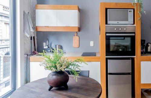 a small kitchen with a table with a vase on it at Loft estilo Industrial junto al MUNAL in Mexico City