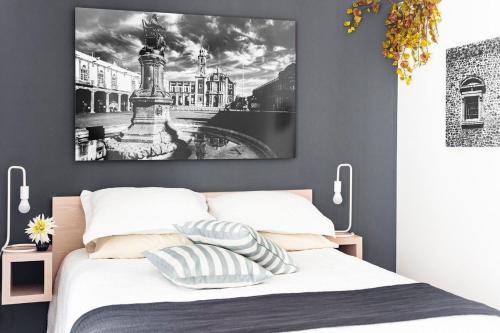 1 dormitorio con 1 cama con una foto en la pared en ROMÁNTICO Junto a Bellas Artes Centro Histórico, en Ciudad de México
