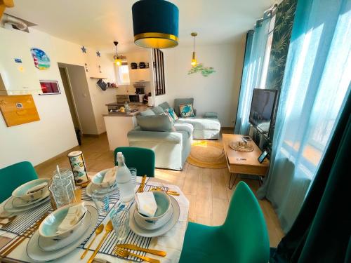 a living room with a table and green chairs at Giulia House Fécamp - Seaside Escape, Modern & Cozy in Fécamp