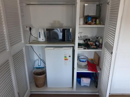 a refrigerator in a kitchen with a microwave at Double Room - Robberg in Plettenberg Bay