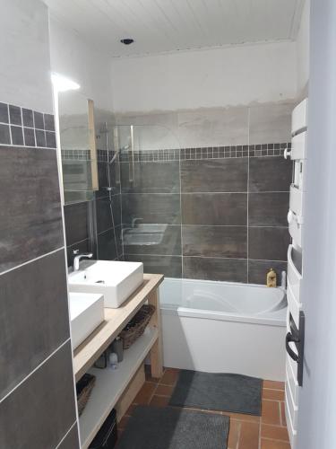 uma casa de banho com um lavatório e uma banheira em La Villa du Tesselier em Noirmoutier-en-l'lle