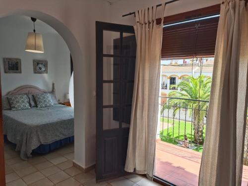 een slaapkamer met een bed en een deur naar een balkon bij Bungalow de vacaciones in Torrevieja