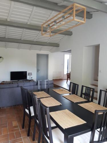 une pièce avec une table, des chaises et une télévision dans l'établissement La Villa du Tesselier, à Noirmoutier-en-l'lle
