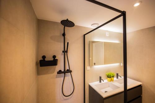 y baño con ducha, lavabo y espejo. en Happily 2 Bedroom Serviced Apartment 75m2 -NB306H-, en Róterdam