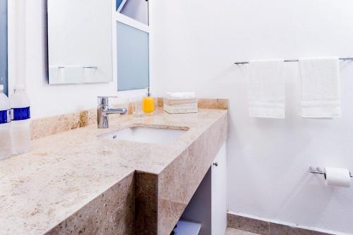 W białej łazience znajduje się umywalka i lustro. w obiekcie A una cuadra del Zócalo Totalmente nuevo w mieście Meksyk
