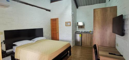 Cet appartement comprend une chambre avec un lit et une petite cuisine. dans l'établissement Acogedora suite en Liguiqui - Manta, 