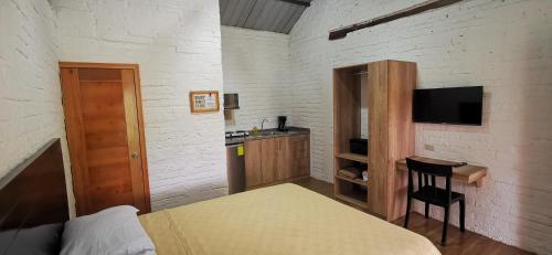 a bedroom with a bed and a desk and a television at Acogedora suite en Liguiqui - Manta in Aromo