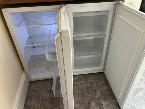 an empty refrigerator with its door open in a kitchen at Oak Dene in Doncaster