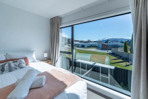 Riverside Lodge- 2 Bedroom Unit في Albert Town: غرفة نوم بها سرير ونافذة كبيرة